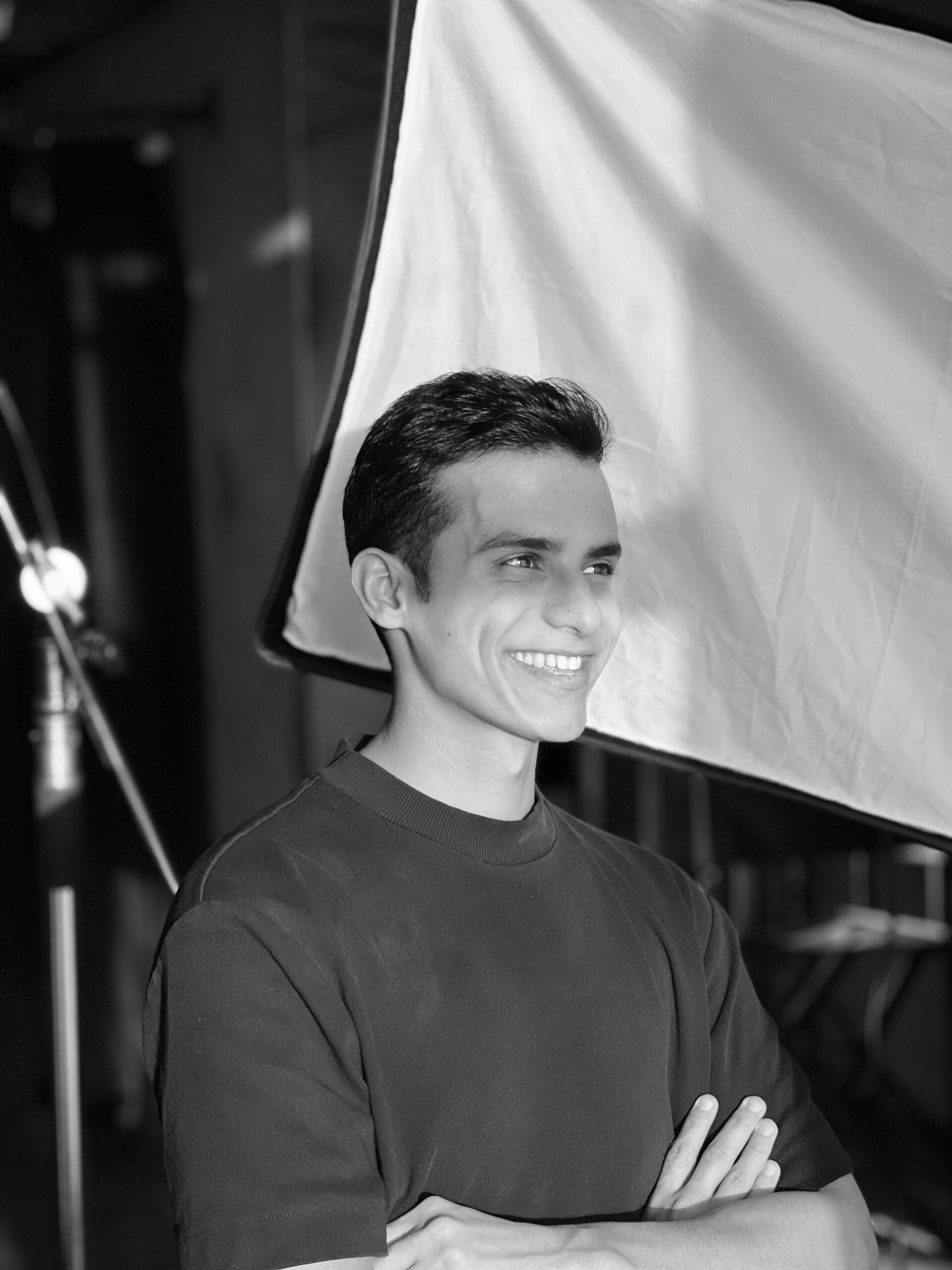 a man standing in front of a camera with his arms crossed